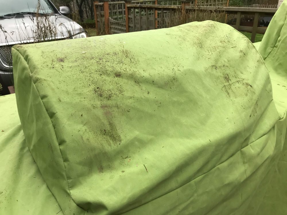 Dirty grill cover that was attacked by a bear