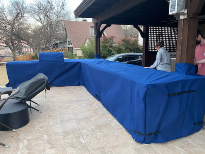 L-Shaped outdoor grill with blue cover